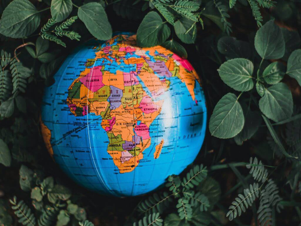 Globe nestled among green foliage focusing on Africa.