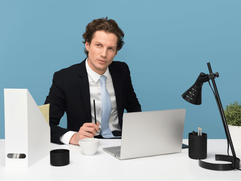 Professional man in a business suit sitting at a desk with a laptop.